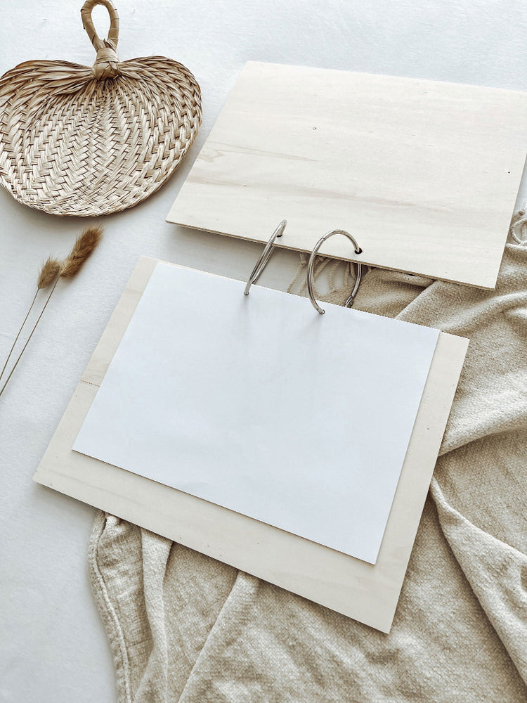 Binnenzijde van houten gastenboek met blanco pagina’s en ringbandbinding